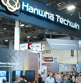 ISC West 2022 attendees explore Hanwha Techwin (Currently Hanwha Vision)’s display featuring AI camera and video analytics solutions.