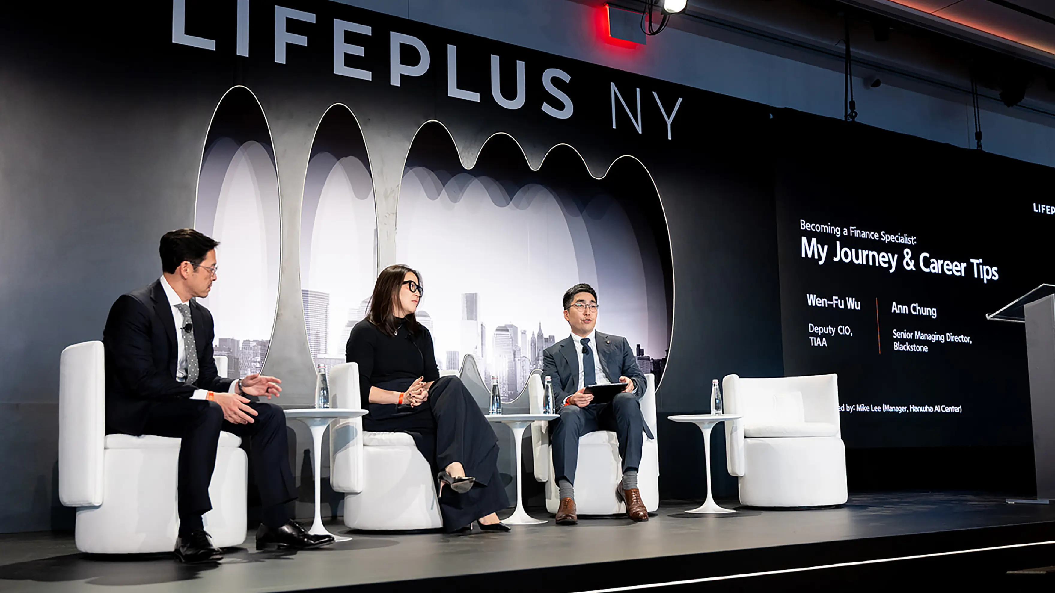 Panelists speak on stage during a LIFEPLUS NY discussion, sharing insights in front of an audience
