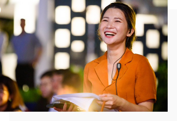 Bich Tien smiles next to the logo of Hanwha Life Vietnam, one of Vietnam’s leading life insurance companies. 