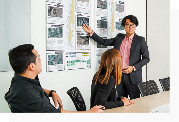 Hanbit Kim leads a meeting in front of other Hanwha Solutions Chile employees.