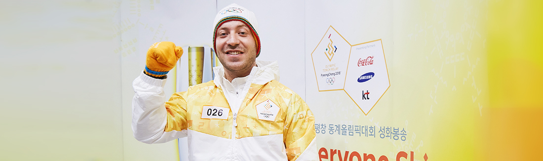 Osama Ayad cheers on Olympic athletes before participating in his leg of the 2018 PyeongChang Winter Olympics Torch Relay