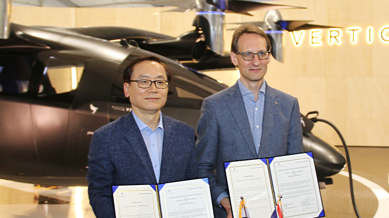 Hanwha Aerospace President and Vertical Aerospace President pose with the VX4 after signing a letter of intent for partnership.