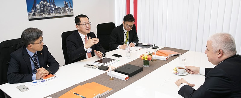Hanwha Total President Charles Kim (second from left) discusses potential partnership opportunities with Tamer Saka (right), CEO of Turkey’s Kibar Holdings, at Hanwha’s Davos office