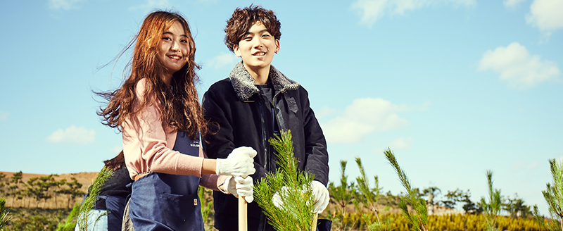 Volunteers at Hanwha Solar Forest No. 7 smile after planting a pine tree