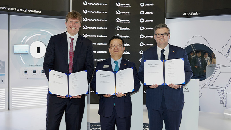 Hanwha Systems CEO Sung-chul Eoh stands between executives from OneWeb and Hanwha Defense Australia and holds the signed MOU.