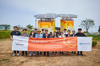 Hanwha Solar Beehive with a banner and people commemorating the event.