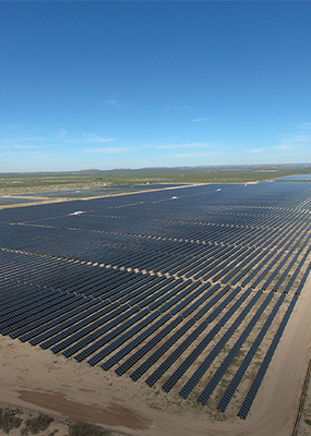 An aerial photo of hundreds of Hanwha Q CELLS solar modules across a wide plain under a blue, sunny sky at a Texas power plant.