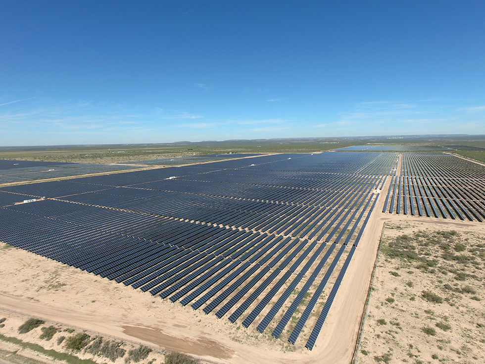An aerial photo of hundreds of Hanwha Q CELLS solar modules across a wide plain under a blue, sunny sky at a Texas power plant