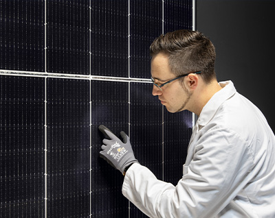 A Hanwha Qcells Employee carefully inspecting PV modules.