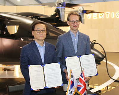 Hanwha Aerospace President and Vertical Aerospace President pose with the VX4 after signing a letter of intent for partnership.