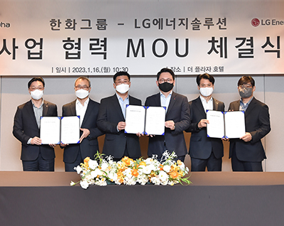 Six Hanwha Group and LG Energy Solution officials pose under a banner at the companies' MOU signing ceremony.
