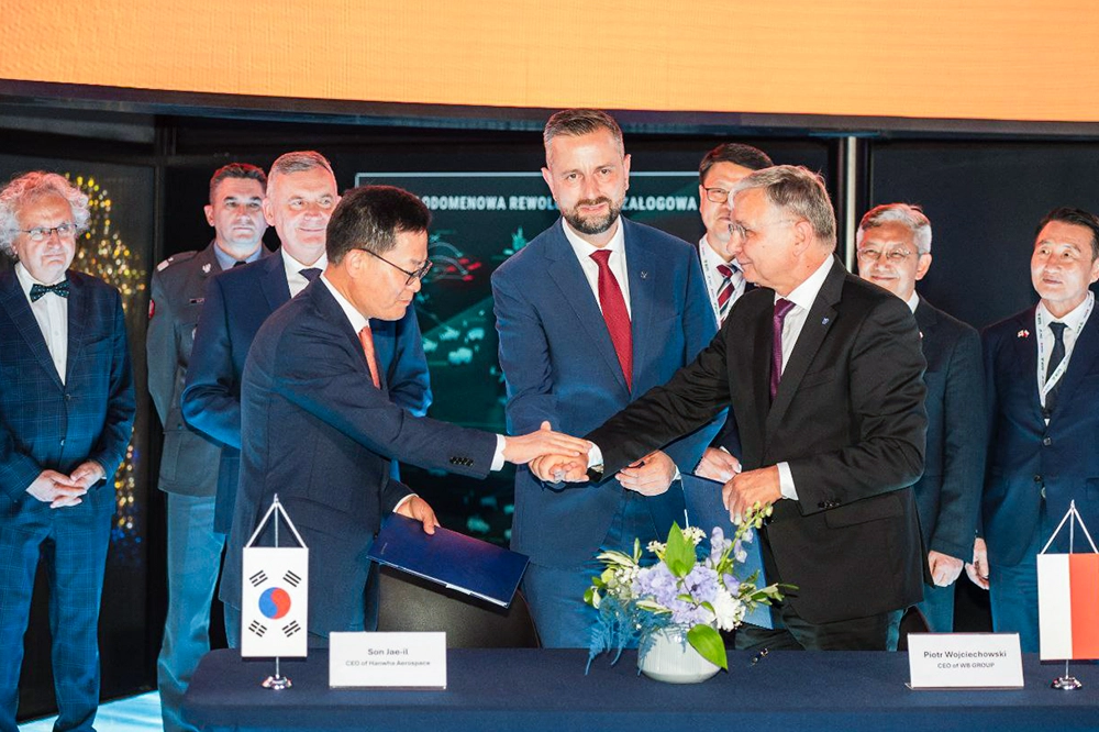 Hanwha Aerospace and WB Group executives sign a joint venture agreement to localize guided missile production in Poland.