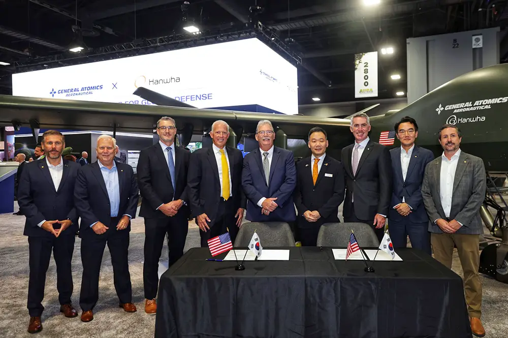 Executives from Hanwha Aerospace and GA-ASI at AUSA 2025 during the UAS co-development agreement signing ceremony.