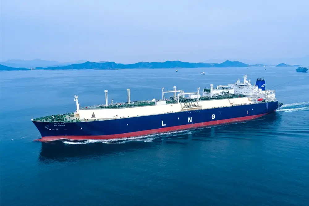 A Hanwha-built LNG carrier sails through open ocean with mountains in the background