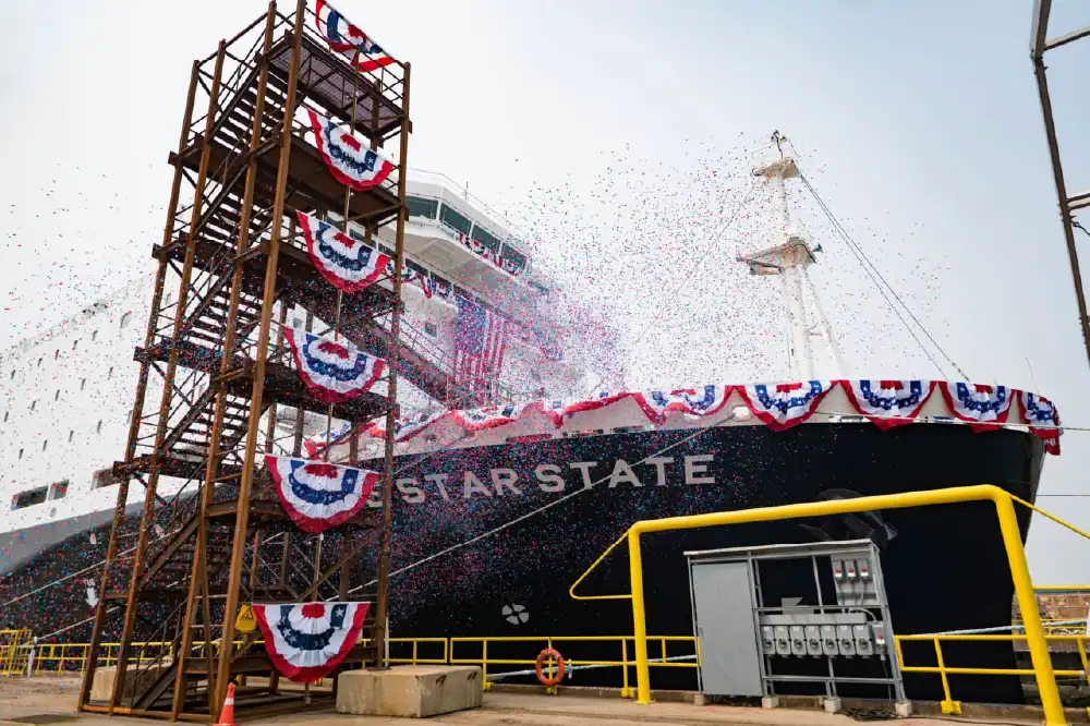 A large vessel with LONE STAR STATE written on the side, with confetti falling and Americana flags draped over the side.