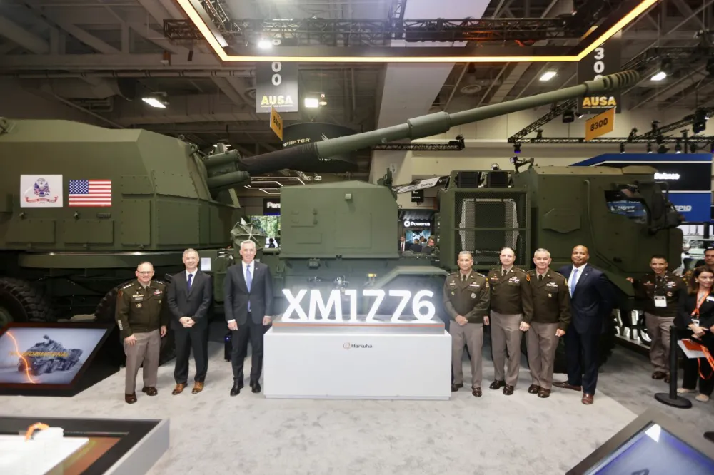 Officials from Hanwha Defense USA and the U.S. Army take a commemorative photo in front of the XM1776.