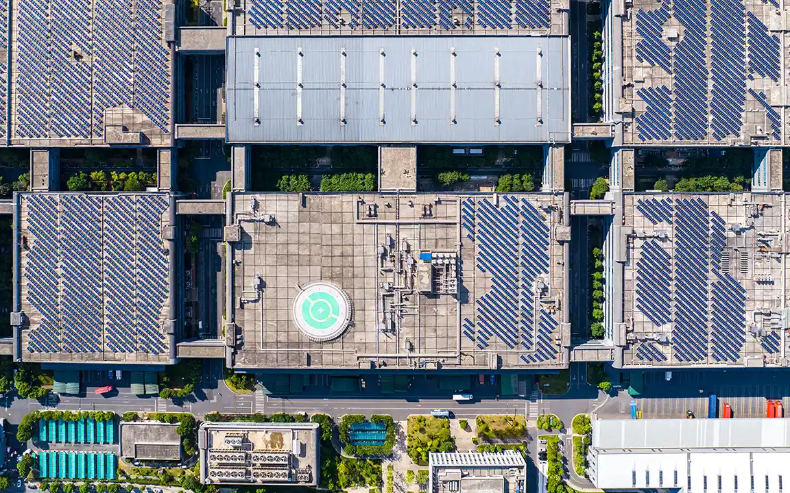 Aerial view of buildings with rooftop solar panels, highlighting solar energy integration in urban infrastructure.