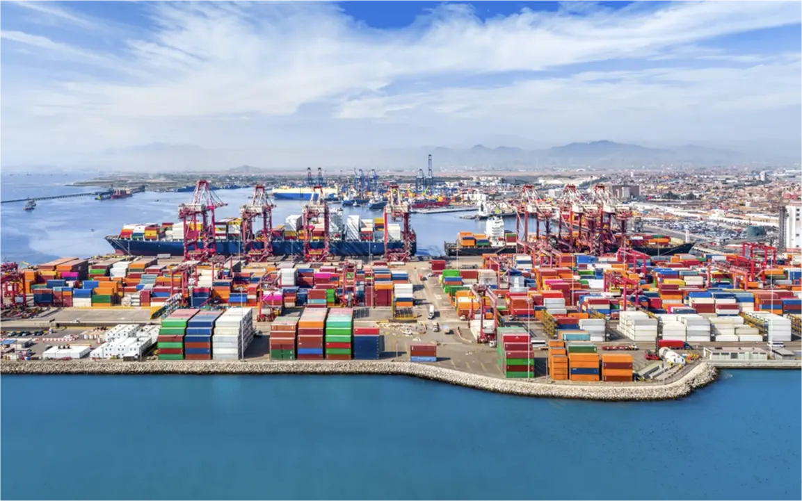 Aerial view of the port in Lima, Peru, showing colorful stacked shipping containers and docked cargo vessels