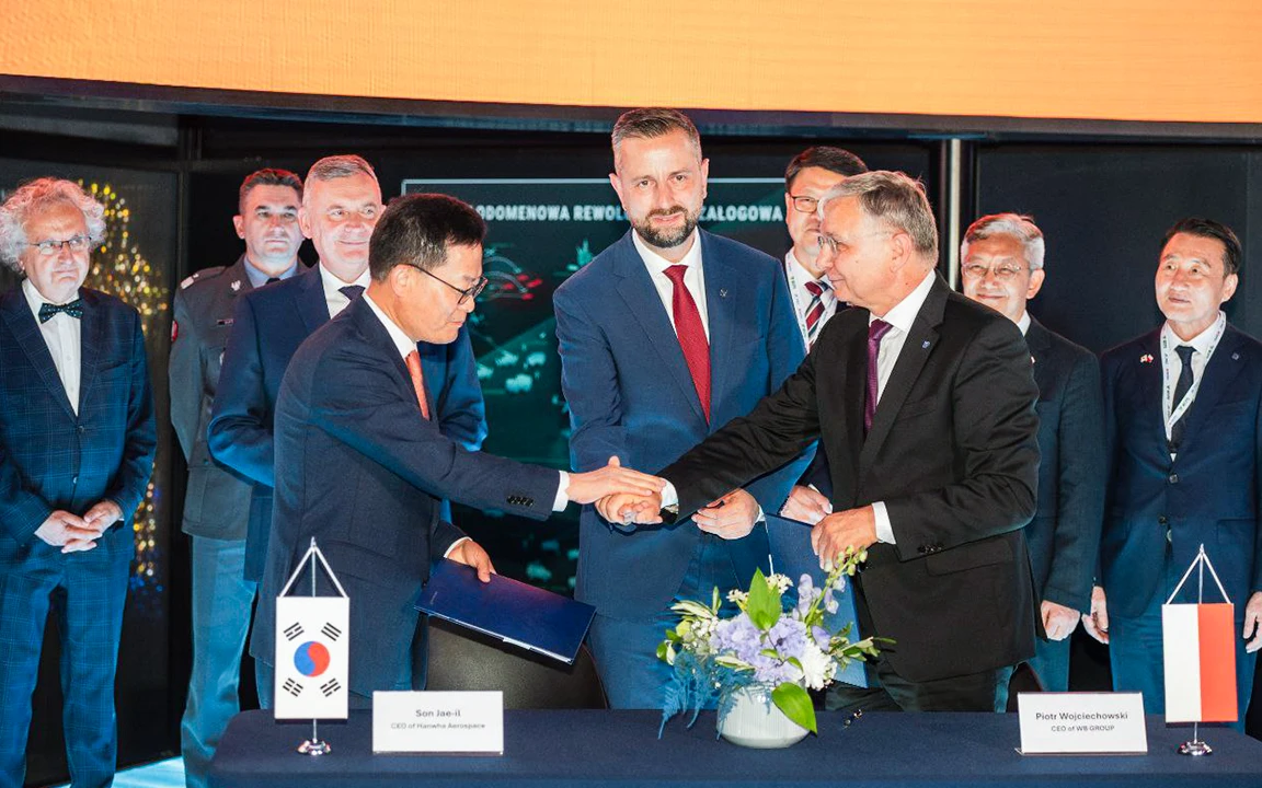 Hanwha Aerospace and WB Group executives sign a joint venture agreement to localize guided missile production in Poland.