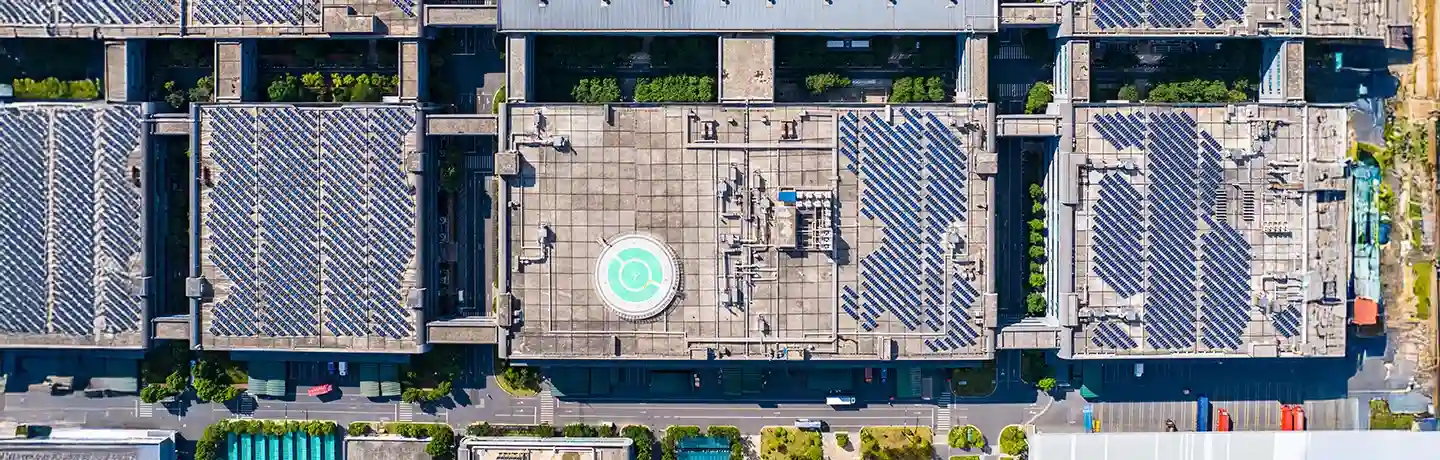 Aerial view of buildings with rooftop solar panels, highlighting solar energy integration in urban infrastructure.