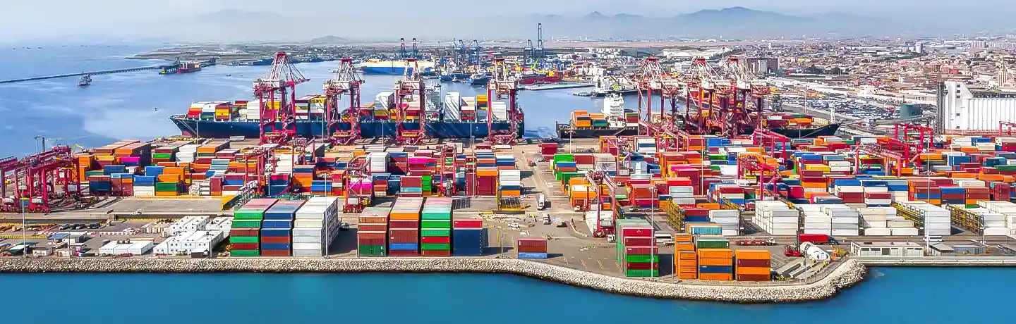 Aerial view of the port in Lima, Peru, showing colorful stacked shipping containers and docked cargo vessels 