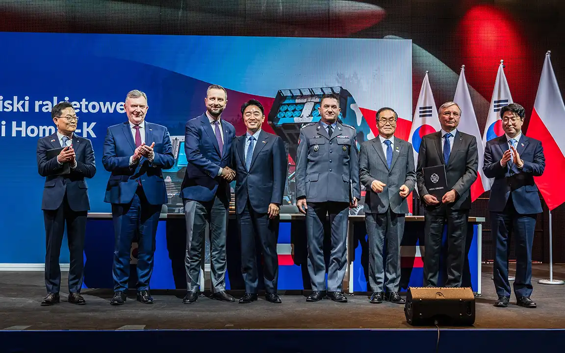 Korean and Polish officials and Hanwha Aerospace executives pose during the Homar-K signing ceremony in Poland.