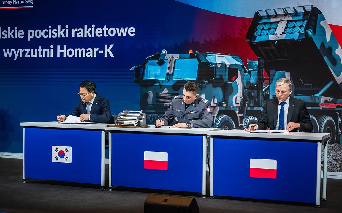 Korean and Polish officials and Hanwha Aerospace executives pose during the Homar-K signing ceremony in Poland.