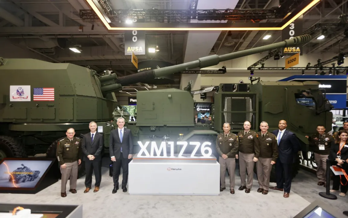 Officials from Hanwha Defense USA and the U.S. Army take a commemorative photo in front of the XM1776.